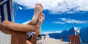 Füße baumeln aus einem Strandkorb