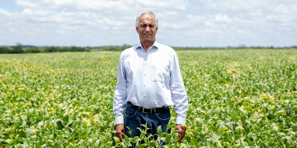 der Farmer Lúcio Damália steht inmitten eines seiner Felder. Im Hintergrund blauer Himmel mit leichter Bewölkung