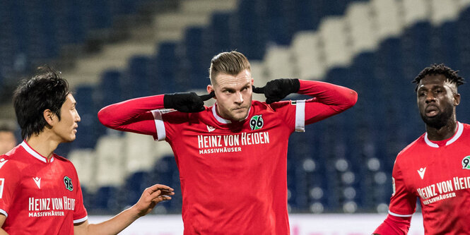 Marvin Ducksch, ein Fußballer von Hannover 96 hält sich auf dem Spielfeld die Ohren zu