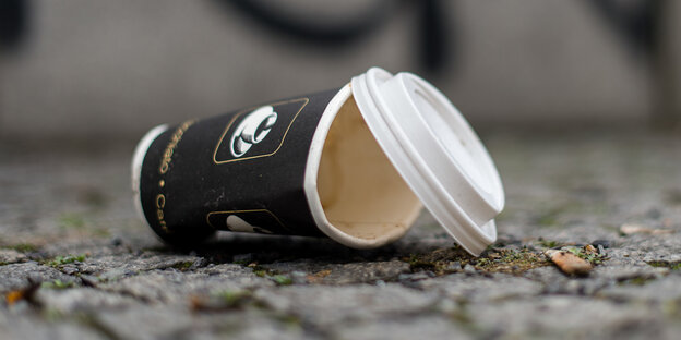 Leerer Kaffeebecher auf der Straße entsorgt