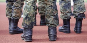 Beine von Bundeswehrsoldaten in Tarnfleckuniformen und schwaren Stiefeln