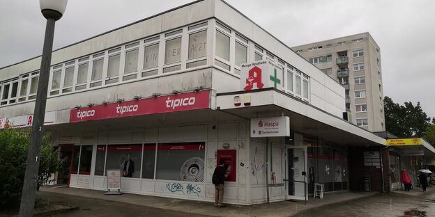 Die Filiale von Tipico von außen, an der Außenwand hebt ein Mann Geld an einem Automaten ab