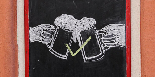 Mit Kreide auf einer Tafel gemalt: zwei Hände, die mit Bierkrügen anstoßen, in der Mitte ein Haken für OK