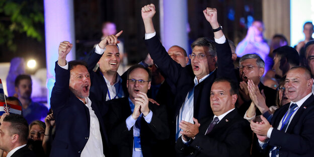 Andrej Plenkovic und andere alte Männer heben die Fäuste in die Luft oder klatschen. Sie jubeln über den Wahlsieg.