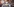 Eine Frau mit Mundschutzmaske hält einen Stimmzettel hoch