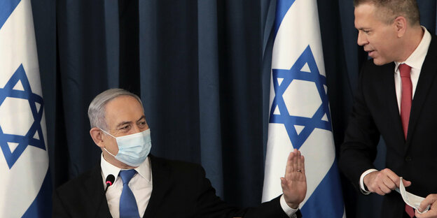 Netanjahu mit Mundschutz. Erdan steht rechts neben ihm