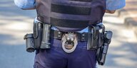 Der Gürtel eines Polizitsen mit Handcshellen und Pistole