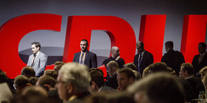 Männer stehen vor dem Parteilogo der CDU