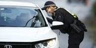 Ein Polizist kontrolliert ein Auto