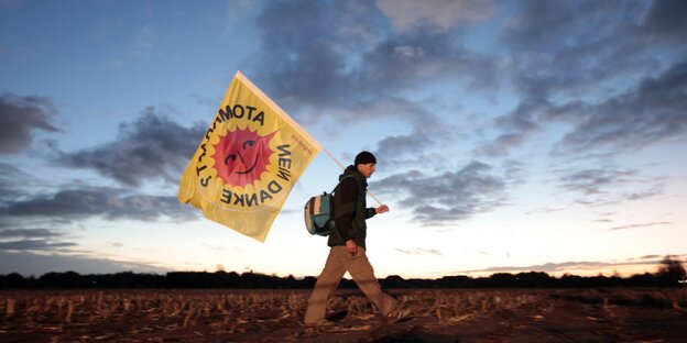 Atomkraftgegner mit Anti-Atom-Flagge vor blauem Himmel