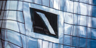 Logo der Deutschen Bank in einer Spiegelung verzerrt