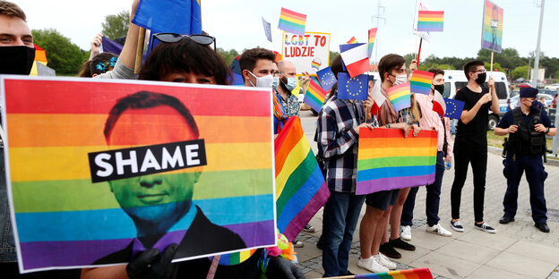 LBGT Anhänger demonstrieren mit Regenbogen und Anti-Duda Plakaten