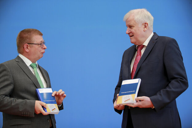 Seehofer und Haldenwang stehen sich gegenüber und halten den Verfassungsschutzbericht in den Händen Seehofer und Haldenwang stehen sich gegenüber und halten den Verfassungsschutzbericht in den Händen