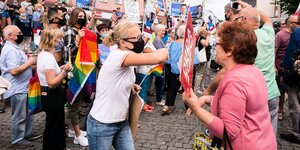 Eine Anhängerin von Präsident Duda mit Schild in der Hand und eine LBTG Aktivistin streiten sich