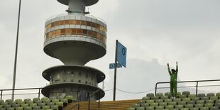 Sitzreihen unter freiem Himmel, ein Fernsehturm im Hintergrund