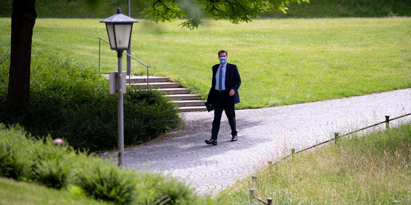 Markus Söder mit Maske beim Spaziergang in einem Park