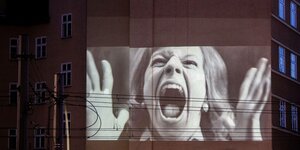 Videoprojektion eine Person in schwarz-weiß auf eine Hauswand