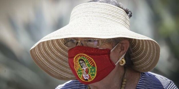 Frau mit Hut und Mund-Nasen-Schutz