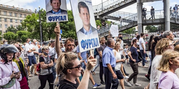 Demonstrat*innen tragen Porträts ihres Gouverneurs Sergej Furgal