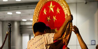 Ein Arbeiter bringt das nationale chinesische Symbol am neuen sicherheitsministerium in Honkong an