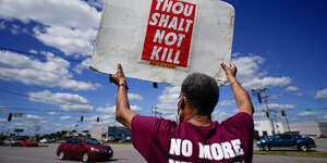Ein Mann hält ein Schild mit der Aufschrift "Du sollst nicht töten" in die Höhe