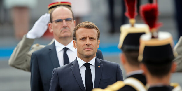 Präsident Macron zwischen Militärs.