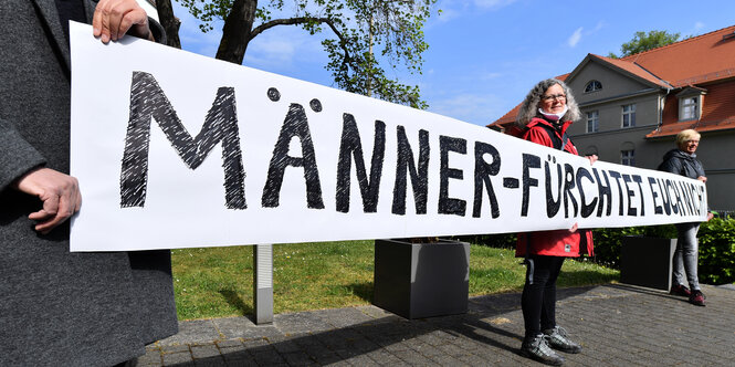 Mehrer Frauen mit einem Banner, auf dem "Männer fürchtet euch nicht" steht.