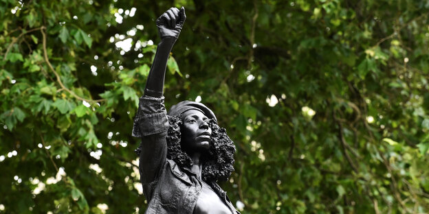 Eine Statue zeigt eine junge Frau mit erhobenem Arm