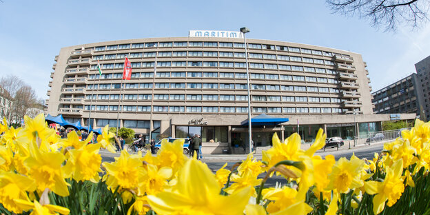 Im Hintergrund ist das Maritim Hotel zu sehen, im Vordergrund blühen gelbe Blumen