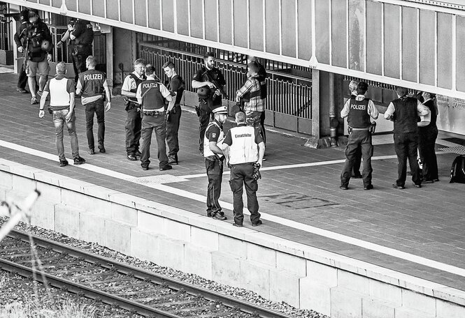 Viele Polizisten stehen auf einem Bahnsteig