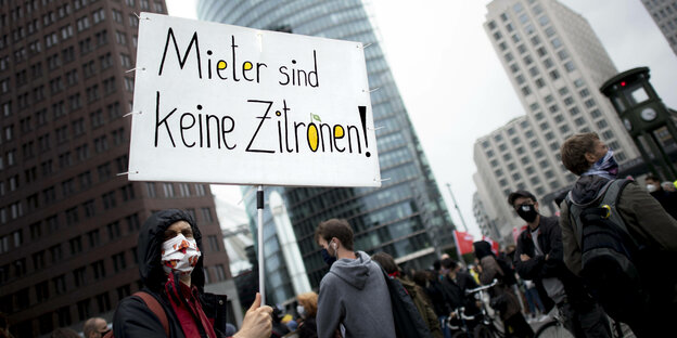 Ein Demonstrant hält ein Schild hoch, auf dem steht: "Mieter sind keine Zitronen"