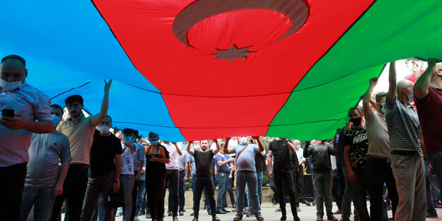 Menschen unter einer aserbaidschanischen Flagge