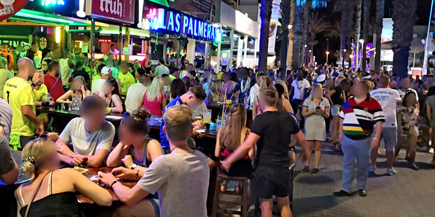 Menschen feiern in der Nacht auf Mallorcas Straßen