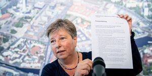 Senatorin für Stadtentwicklung Katrin Lompscher hält bei einer Präsentation des Mietendeckel-Entwurfs ein Blatt Papier hoch