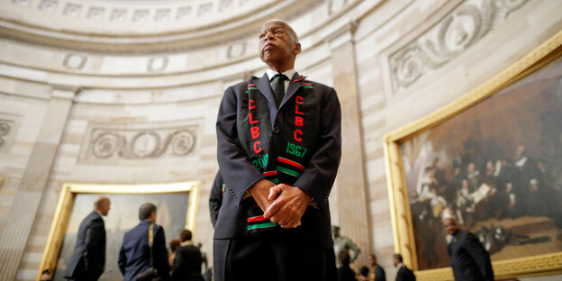 John Lewis im Kapitol in Washington. Er trägt eine schwarze Robe und einen bunten Schal.