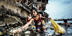 Fotografie von Kindern, die im Wasser nach Müll fischen