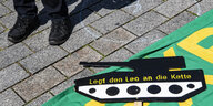 ein aufs Gehwegpflaster gemalter Panzer mit der Aufschrift "Legt den Leo an die Kette"