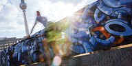 Ein Radfahrer passiert den vom Künstler Age Age gestalteten Bauzaun am Alexanderplatz