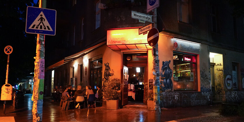 Nachtschwärmer sitzen vor einer Bar im Kneipenviertel der Weserstraße in Berlin-Neukölln. Bars und Restaurants haben wieder ohne Sperrstunde geöffnet.