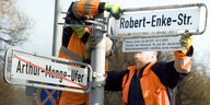 Arbeiter montieren im Januar 2011 in Hannover den Straßennamen "Robert-Enke-Straße"ichenen Straßenschild Arthur-Menge-Ufer