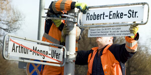 Arbeiter montieren im Januar 2011 in Hannover den Straßennamen "Robert-Enke-Straße"ichenen Straßenschild Arthur-Menge-Ufer
