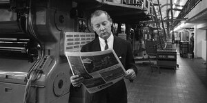 Ein Mann mit Zeitung in einer Druckerei