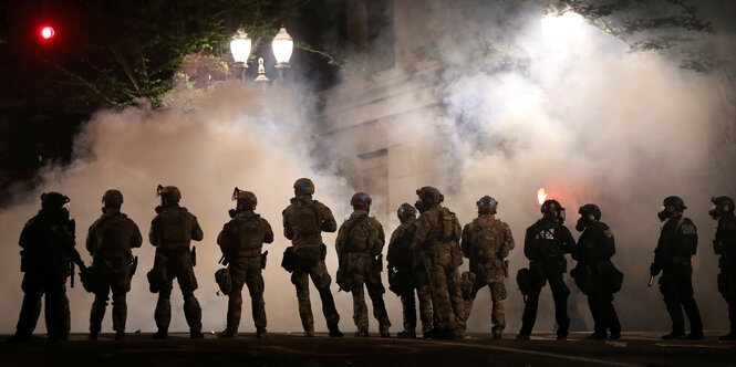 Silhouetten von Soldaten vor einer Rauchwolke