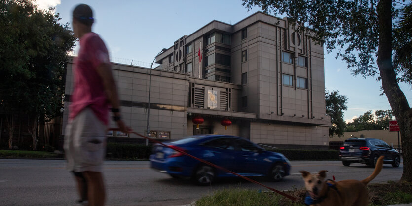 Ein Mann mit hund spaziert vor dem chinesischen Generalkonsulat in Houston