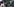 Eine schwarze Frau mit T-Shirt und ein weißer Mann in Polizeiuniform stehen sich gegenüber.