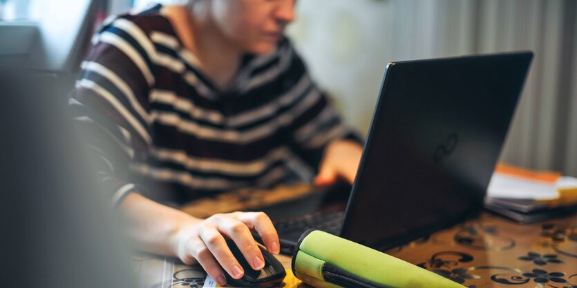 Ein Mann sitzt vor einem Laptop