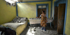 Eine Frau in ihrem zerstörten Haus in Tovuz