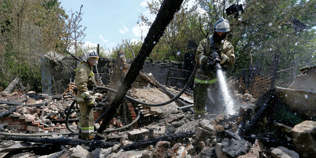 Feuerwehrleute löschen ein abgebrantes Haus in Dontesk, das mutmaßlich von Rebellen beschossen wurde
