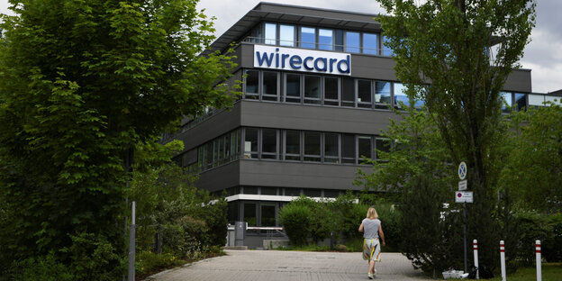 zwischen Bäumen steht ein Gebäude mit der Aufschrift "Wirecard"