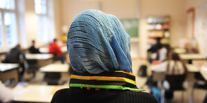 Schülerin mit Kopftuch sitzt in einem Klassenraum
